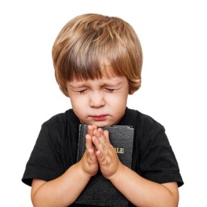 16028601 - little boy praying with the bible in hand